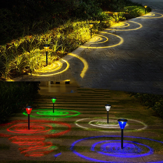 Glowing garden lights casting colorful circular patterns on a pathway at night.
