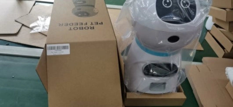Pet feeder robot with packaging on a cardboard box